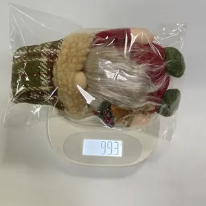 Detailed view of a Christmas gnome plush toy on a digital scale showing 99.3g weight.