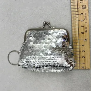 Detail view of a mini silver sequin coin purse with a retro metal clasp and key ring