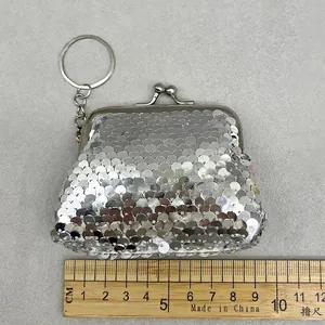 Detailed macro view of a silver sequin mini coin purse with vintage metal clasp and keychain