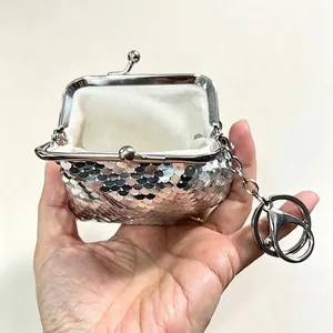 Detailed view of the open silver sequined coin purse showing the white interior lining