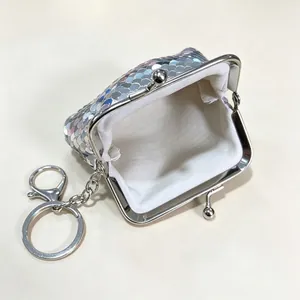 Detailed interior view of a silver sequined mini coin purse with a sturdy metal clasp