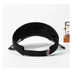 Detail of black sports sun visor with adjustable Velcro strap and striped accent