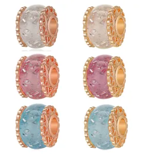Handmade resin beads with silver foil flakes and heart pattern caps for DIY jewelry.