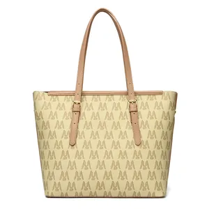 Close-up detail of a beige tote bag featuring a repeating M monogram and tan straps