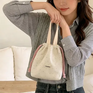 Small cream polka dot corduroy drawstring handbag with pink ties for daily outings