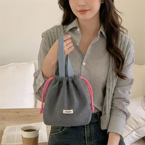 Detailed view of grey wool drawstring bag with white polka dots and pink cord