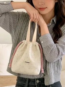 Elegant cream polka dot drawstring handheld bag for casual outings or bento storage