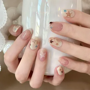 Close-up detail of short oval nude pink press-on nails featuring elegant star patterns