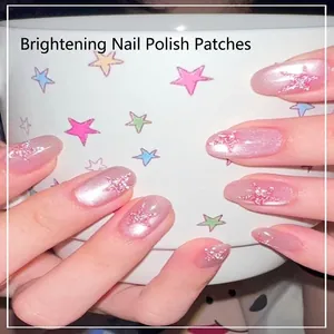 Close-up of pink glittery gradient press-on nails with star decals on short oval shape