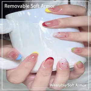 Short oval press-on nails with colorful French tips and dot patterns on a nude base.