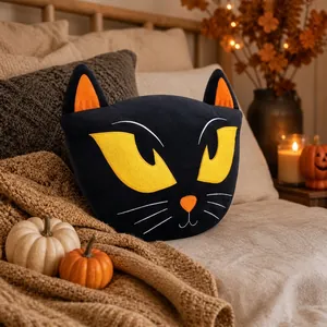 Dettaglio di un simpatico cuscino di peluche a gatto nero in un ambiente autunnale Halloween