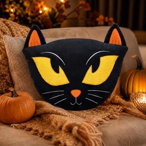 Dettaglio del cuscino di peluche a forma di gatto nero per Halloween in ambiente accogliente