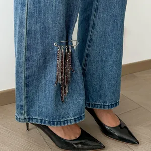 Elegante silberne Sicherheitsnadel-Brosche mit dunklen Perlenquasten an der Jeans
