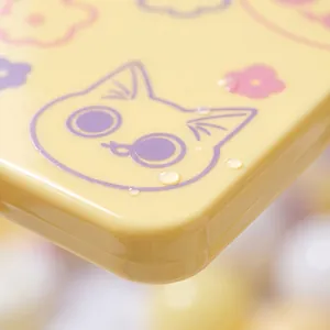 Close-up macro detail of yellow cat makeup mirror featuring waterproof glossy finish
