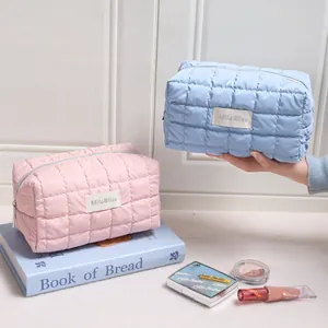 Twee zachte gewatteerde bubble grid make-up tassen in pastelroze en lichtblauwe kleur