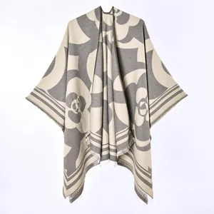 Detailed view of the fabric texture and camellia floral pattern on this warm poncho shawl