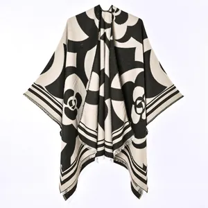 Detail of reversible faux cashmere poncho shawl with black and beige camellia pattern