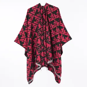 Detailed view of women's faux cashmere front slit cloak shawl with red and black geometric pattern