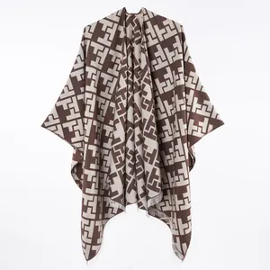 Close-up of brown geometric pattern faux cashmere poncho with fringe detail