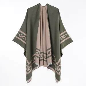 Detail of reversible olive green and tan poncho with scroll pattern and fringe