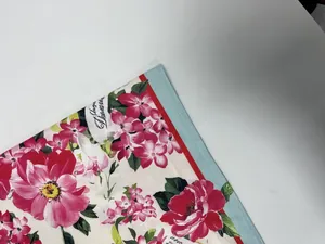 Macro view of vibrant pink floral print on cream fabric with blue piping detail