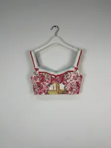 Close-up of floral print cropped camisole top with architectural graphic and red straps