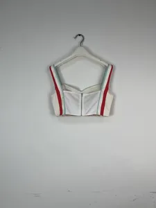 Detailed back view of white bustier top featuring red and blue striped straps and zipper