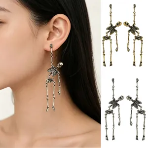 Detailed view of retro skeleton earrings in gold and silver with on-ear model showcase