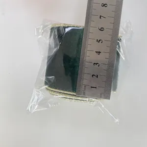 Close-up of 6cm dark green velvet ribbon with gold wire edges and measurement ruler