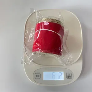 Detailed view of 6cm red velvet ribbon with gold wired edges weighing 61.2g on a scale