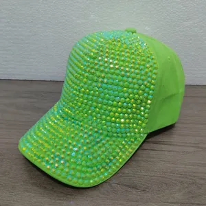 Vista detallada de una gorra de béisbol verde neón cubierta con brillantes diamantes de imitación.