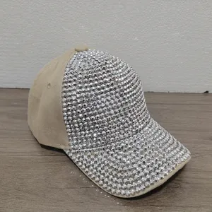 Vista detallada de una gorra de béisbol color caqui con brillantes pedrería plateada.