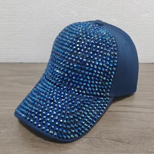 Primer plano de una gorra de béisbol con pedrería azul y acabado de cristal brillante.