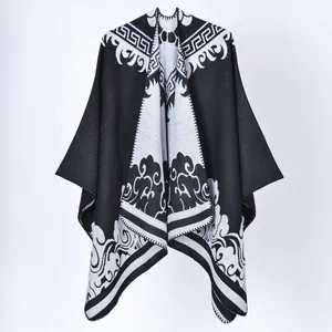 Vue détaillée d'un poncho tricoté noir et blanc avec dentelle et motif grec.
