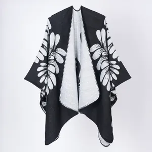 Vue détaillée du motif de feuilles noir et blanc sur ce châle poncho en maille pour femmes