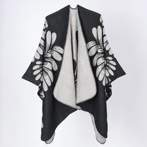 Détail d'un poncho en tricot pour femme avec motif floral noir et blanc et devant ouvert