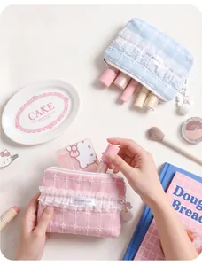 Detailansicht einer rosa Tweed-Make-up-Tasche mit Spitze und flauschigem Anhänger