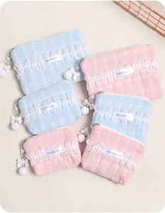 Sortierte rosa und blaue Spitzen-Kosmetiktaschen mit Schleifen- und Bommelanhängern