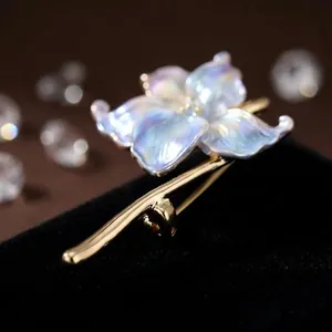 Détail macro de l'élégante broche nénuphar en émail avec pétales irisés et finition dorée