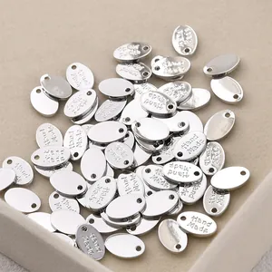 Macro detail of silver oval jewelry tags with Hand Made engraving for DIY crafts