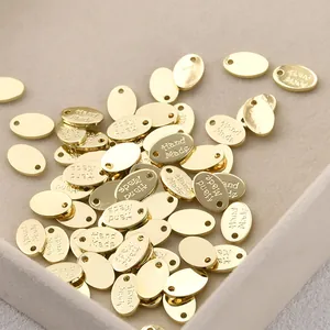 Close-up of 14k gold plated copper oval tags with Hand Made engraving for DIY jewelry.