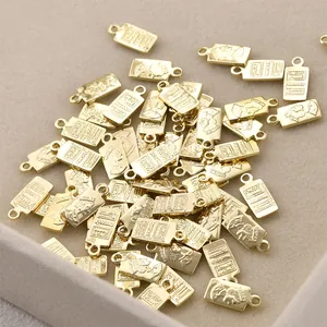 Close-up detail of bulk 14K gold plated rectangular charm pendants with queen portraits