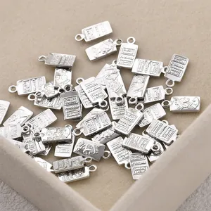 Close-up of silver-plated rectangular charms with Queen Elizabeth and bullion design