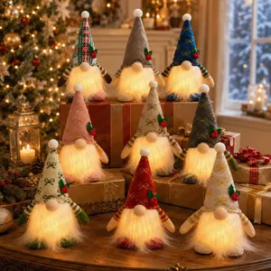Gruppo di gnomi di Natale luminosi in peluche su sfondo di scatole regalo festive