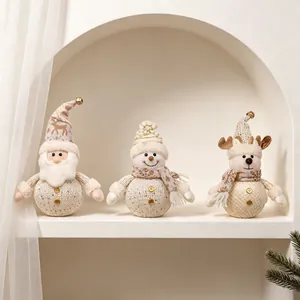 Drie schattige gebreide kerstornamenten met kerstman, sneeuwpop en rendier op een plank