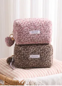 Detail view of plush leopard print cosmetic bags featuring soft faux fur texture
