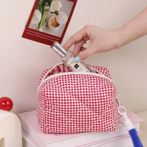 Trousse à maquillage matelassée à carreaux rouges et blancs avec pompon bleu en fourrure