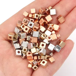 Gedetailleerde macro-opname van zilveren en roségouden CCB-metalen kubuskralen voor DIY