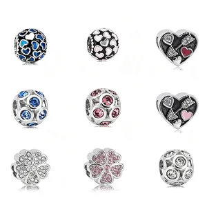 Detalle de nueve dijes de plata surtidos para joyería con cristalli y esmalte de color