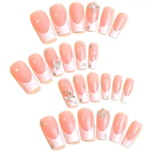 Faux ongles French manucure avec breloques papillon argentées et strass scintillants